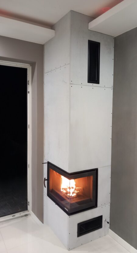 Eckkamin mit brennendem Feuer und heller Verkleidung im Wohnzimmer